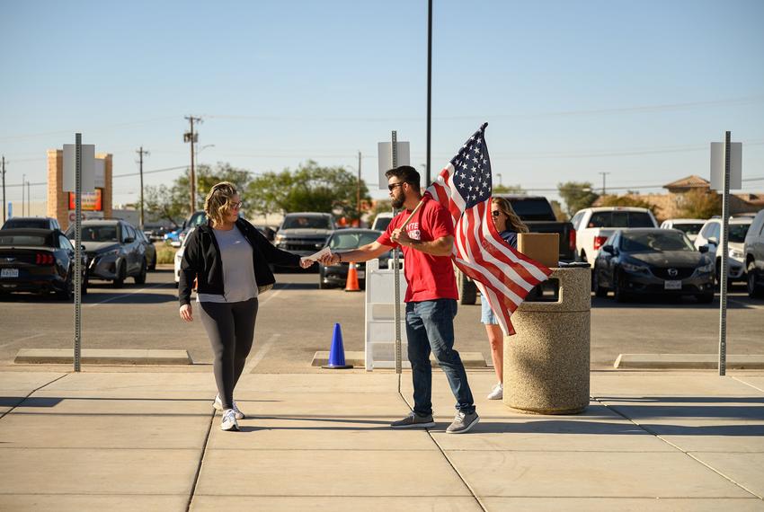 Volunteer Landry Pugh shakes hands with voters outside a polling place in Odessa on Oct. 28, 2024.